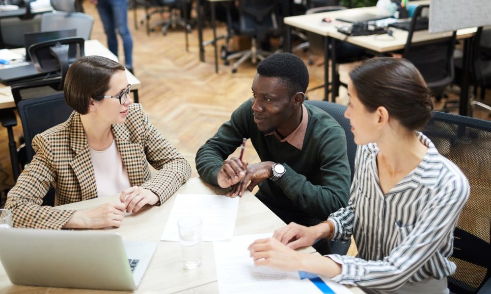 Three people at a table talking