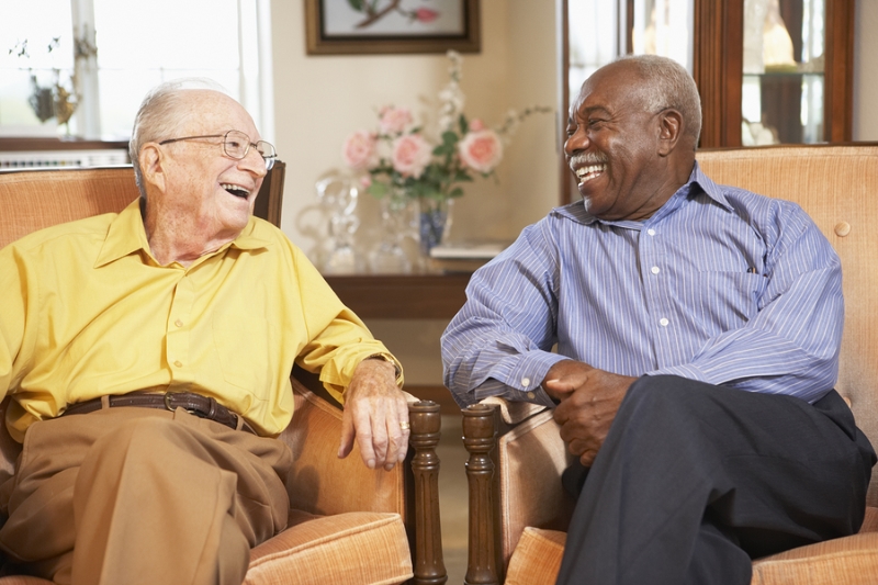 Two senior men sitting in chairs next to each other