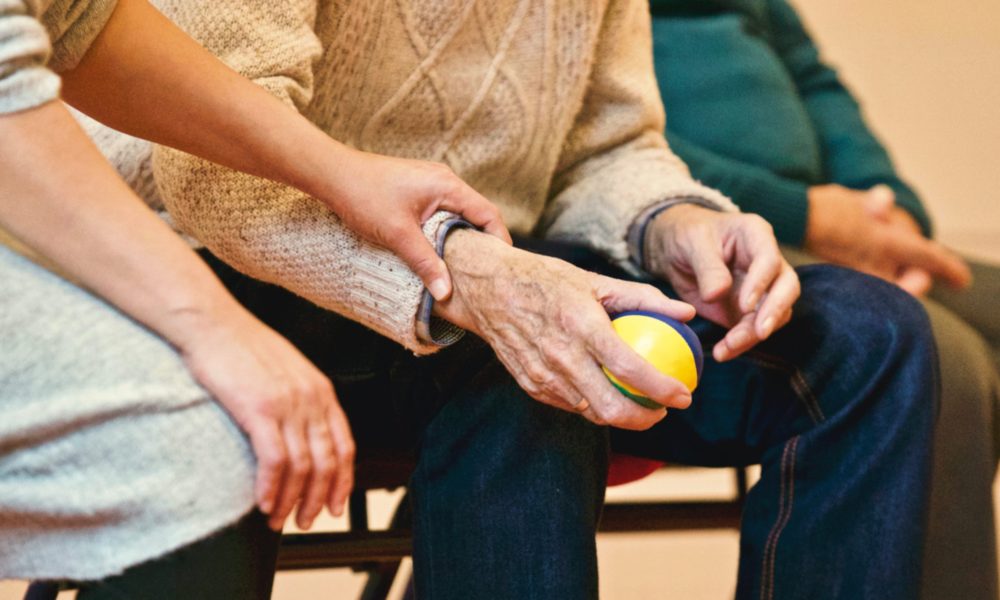 Photograph of people sitting holding hands