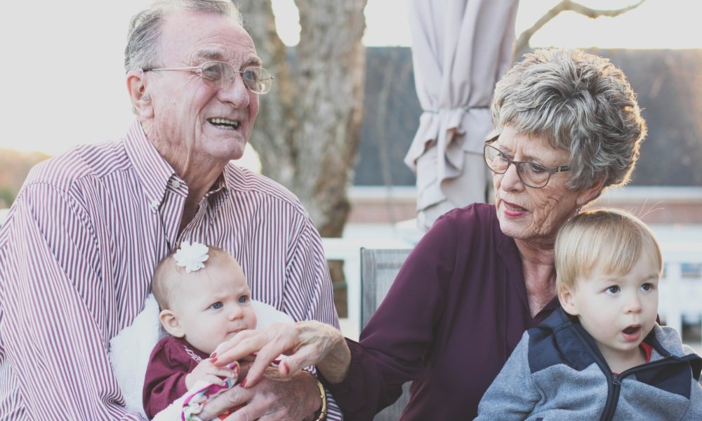 older adults holding children