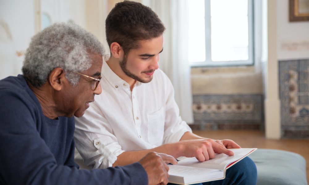 Young man reading to older man