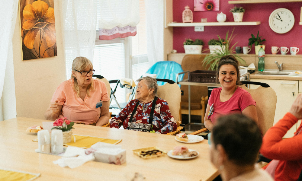 women gathered around table, smiling